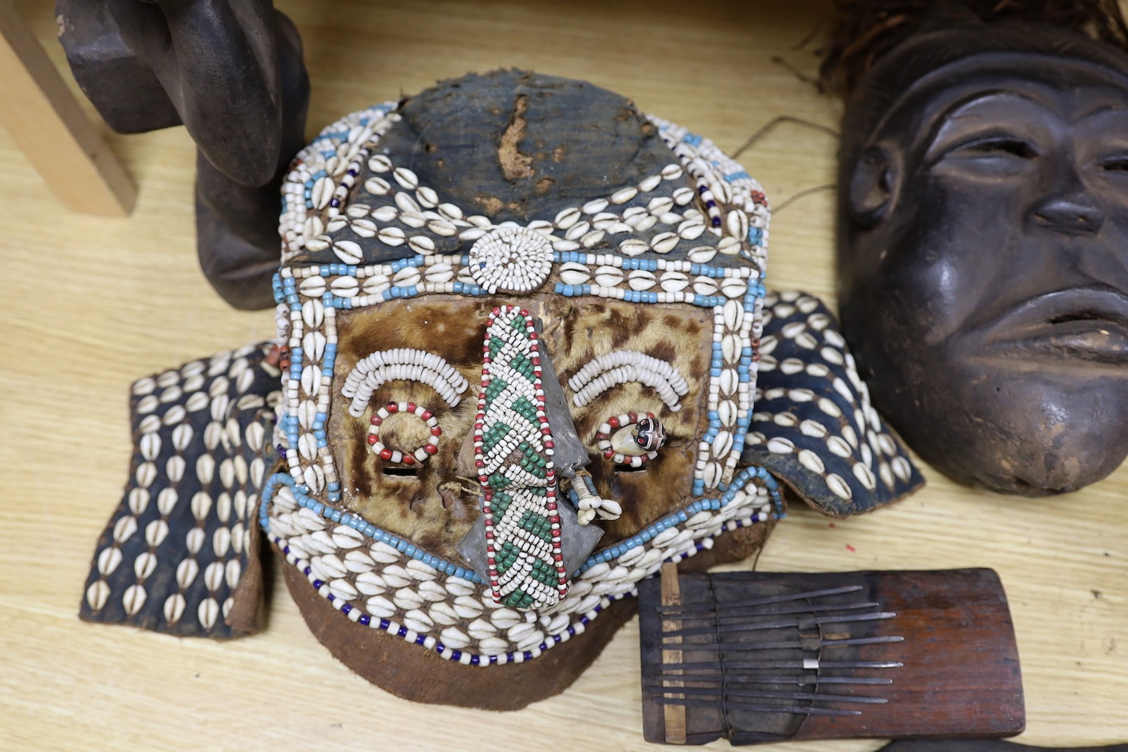 A group of Democratic Republic of Congo tribal carved wood figures and instrument and a Kuba style beadwork and shell mount mask